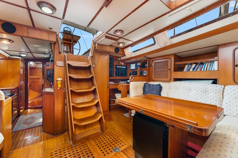Slide: The Image of Interior of 1996 Tayana 58 yacht with wooden furnishings and cozy seating area. - 4