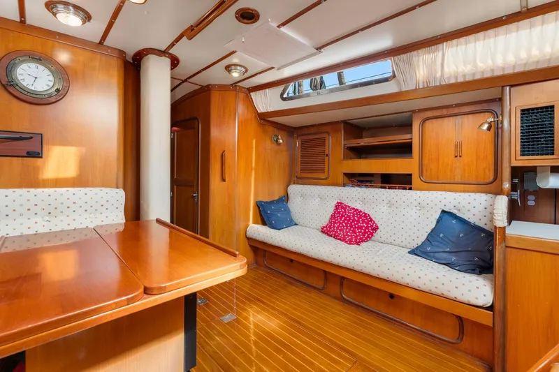 Slide: The Image of Luxurious 1996 Tayana 58 yacht interior with wooden finish and cozy seating area. - 5