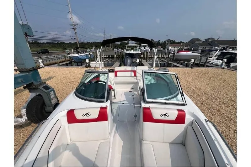 Slide: The Image of 2015 Monterey 217 Blackfin boat with red and white interior, docked at a marina. - 11
