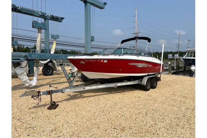 Slide: The Image of 2015 Monterey 217 Blackfin boat on trailer, red and white, parked on gravel. - 6