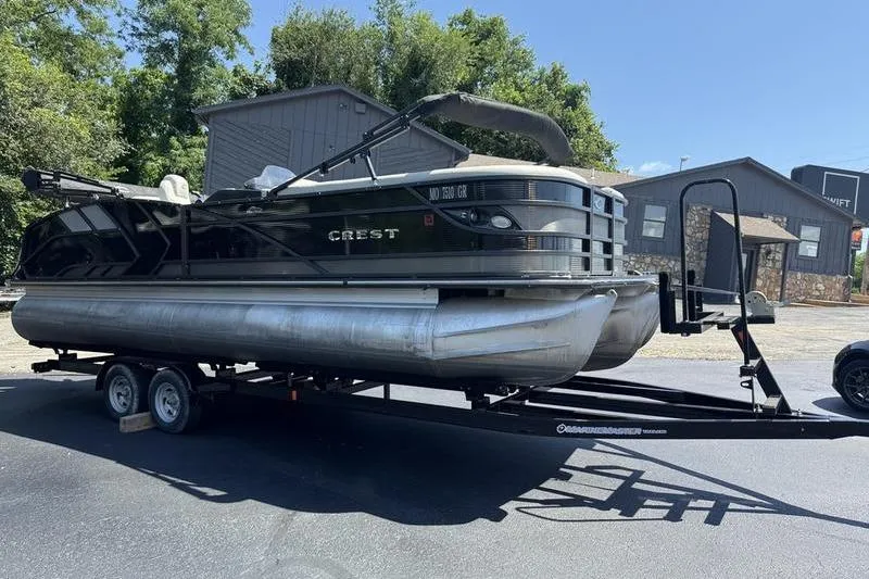 Slide: The Image of 2020 Crest Caribbean LX 250 SLC pontoon boat on trailer, parked outdoors. - 11