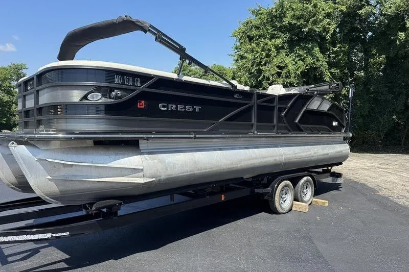 Slide: The Image of 2020 Crest Caribbean LX 250 SLC pontoon boat on trailer, parked outdoors. - 12