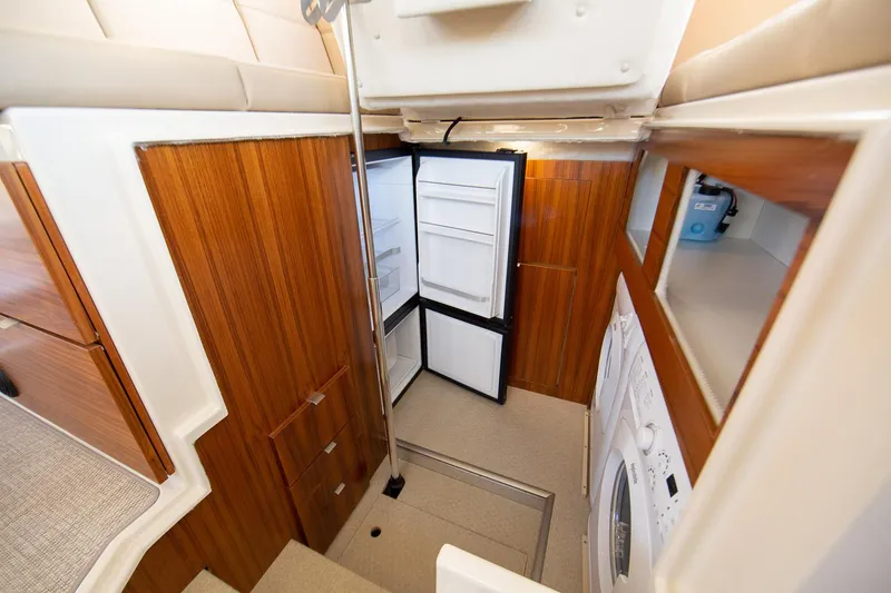 Slide: The Image of Interior of 2025 Ranger Tugs R-43 S with open fridge and washer. - 13