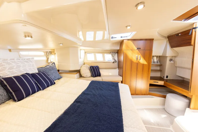 Slide: The Image of Luxurious 2025 Ranger Tugs R-43 S cabin interior with elegant bedding and wood accents. - 15