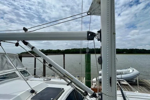 Slide: The Image of 2016 Gozzard 41 RC sailboat docked by a calm river under a cloudy sky. - 10