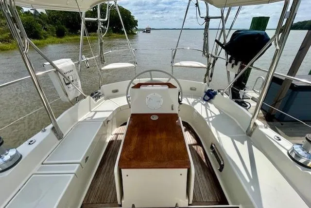 Slide: The Image of Cockpit view of 2016 Gozzard 41 RC sailboat with wooden seating and scenic water backdrop. - 19