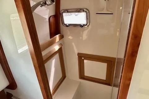 Slide: The Image of 2016 Gozzard 41 RC yacht bathroom with wooden accents and porthole window. - 35