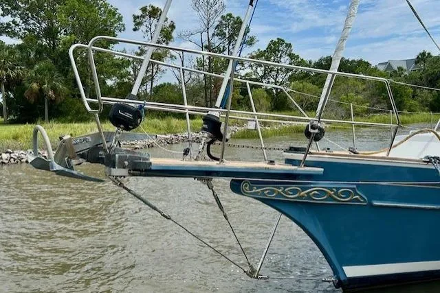 Slide: The Image of 2016 Gozzard 41 RC sailboat bow with decorative detailing, anchored near lush shoreline. - 4