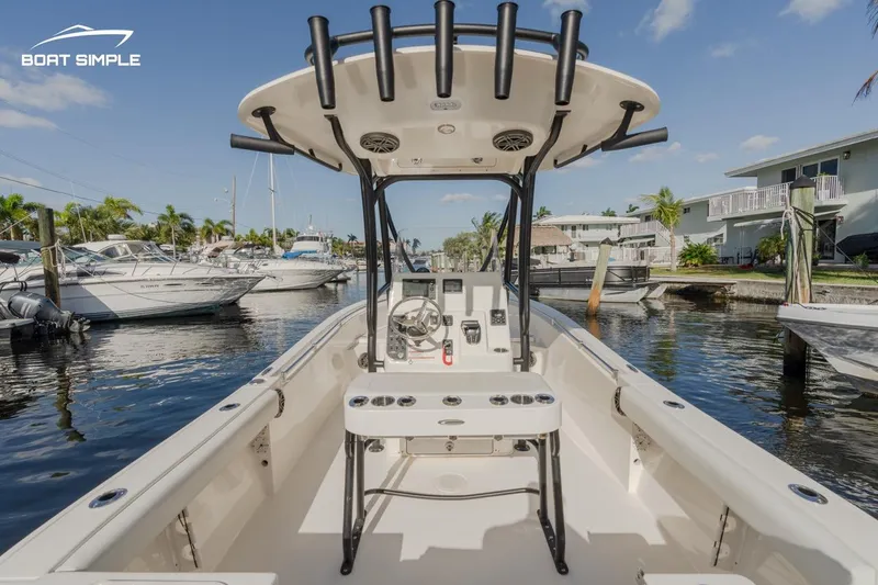 Slide: The Image of 2023 Cobia 220 Center Console boat docked in a marina under clear skies. - 3