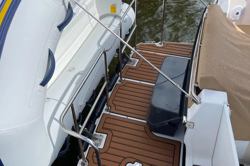 Slide: The Image of Ranger Tugs R-31S 2025 model boat deck with wooden flooring and safety rails. - 11