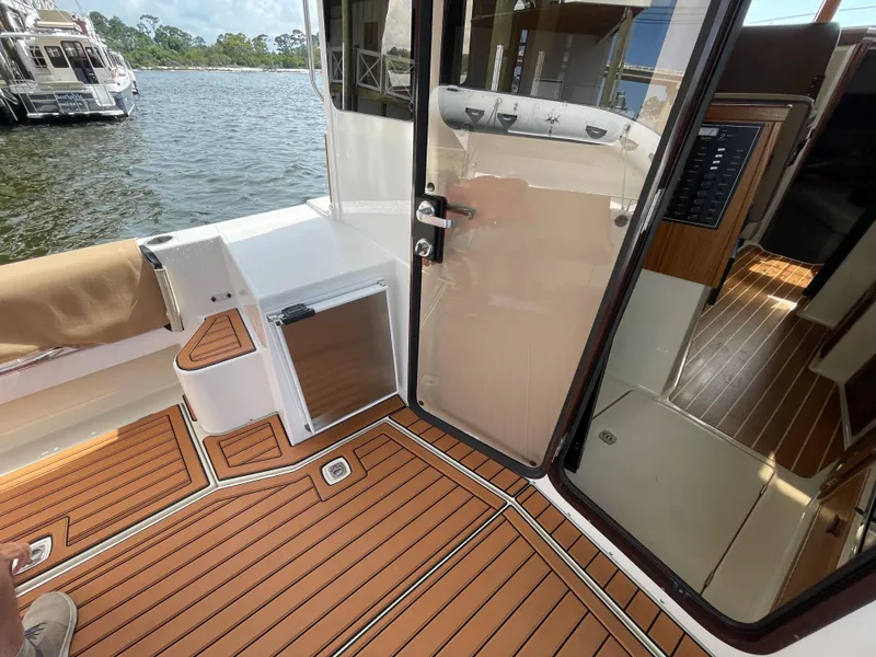 Slide: The Image of 2025 Ranger Tugs R-31S boat interior with teak flooring and water view. - 21