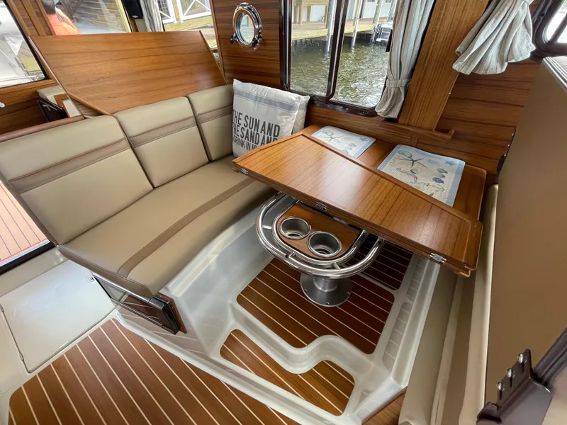 Slide: The Image of Interior of 2025 Ranger Tugs R-31S with dining area and wooden accents. - 26