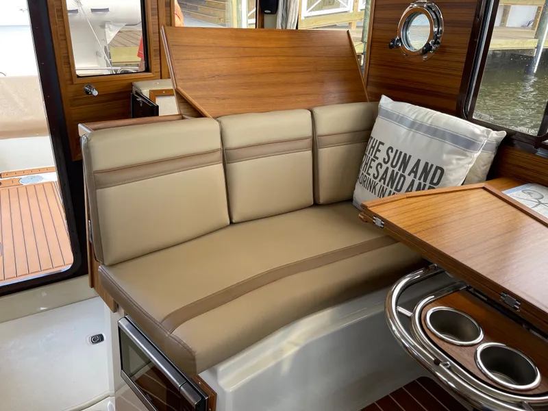 Slide: The Image of 2025 Ranger Tugs R-31S interior seating area with cushion and table. - 27