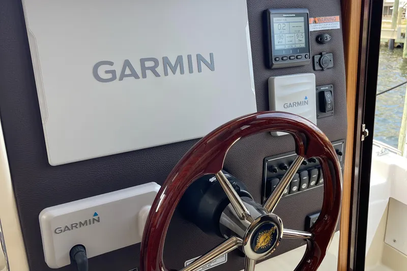 Slide: The Image of Ranger Tugs R-31S 2025 helm with Garmin navigation system and wooden steering wheel. - 31