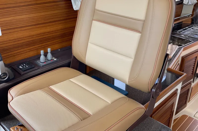 Slide: The Image of Captain's chair in 2025 Ranger Tugs R-31S boat, featuring beige and tan upholstery. - 33