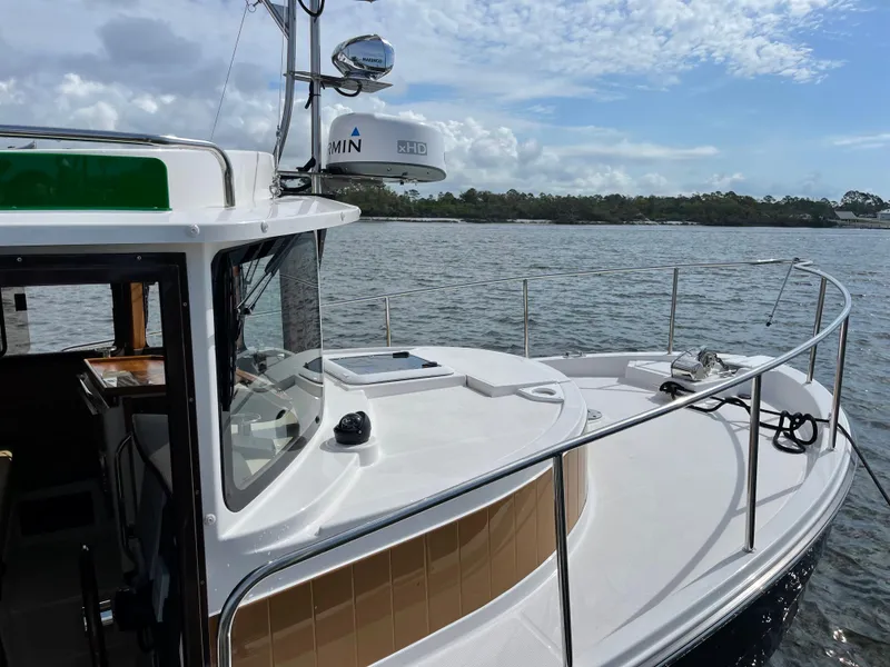 Slide: The Image of 2025 Ranger Tugs R-31S boat on calm water with clear sky. - 6