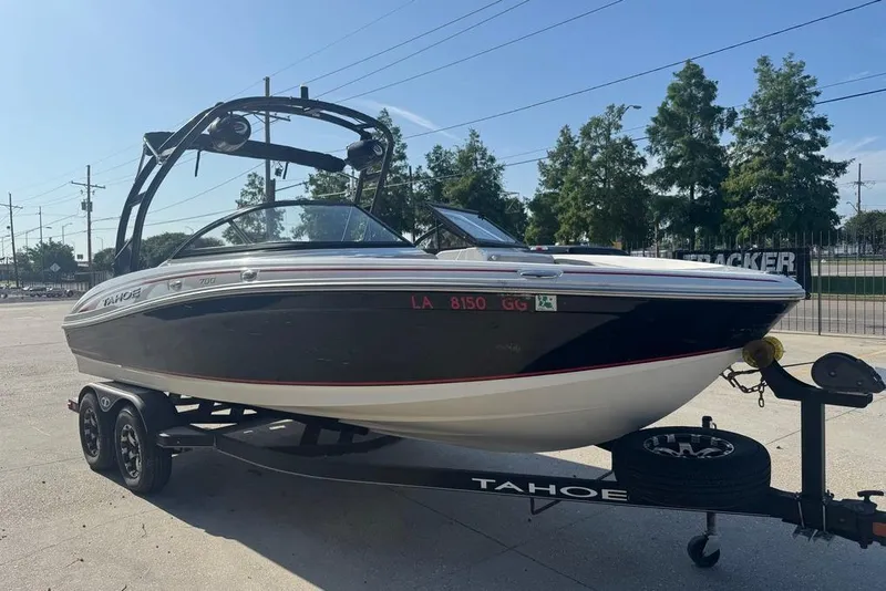 Slide: The Image of 2018 Tahoe 700 TF boat on trailer, parked outdoors under clear sky. - 5