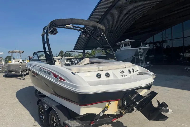 Slide: The Image of 2018 Tahoe 700 TF boat on trailer, parked outdoors near a building. - 9