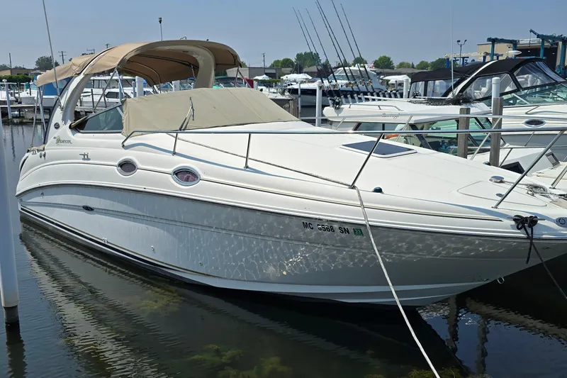 The Image of 2003 Sea Ray 280 Sundancer boat docked in marina, featuring sleek design and beige canopy. - 1