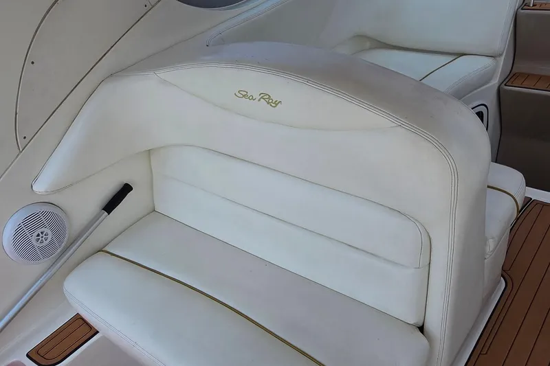 Slide: The Image of 2003 Sea Ray 280 Sundancer boat interior with white seating and speaker. - 11