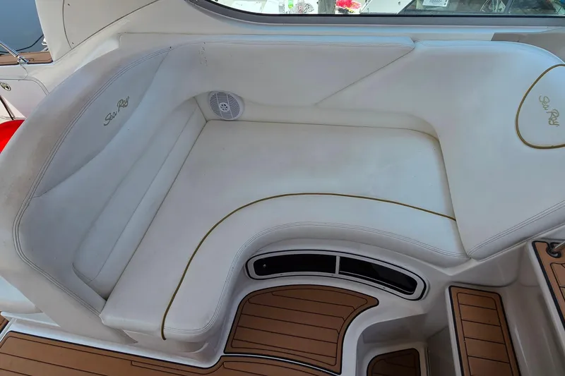 Slide: The Image of 2003 Sea Ray 280 Sundancer interior seating with white upholstery and wood accents. - 12