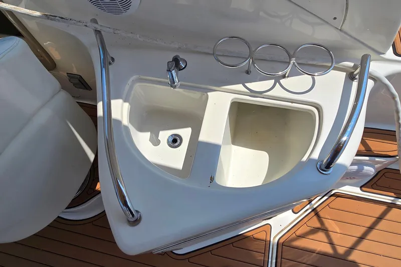 Slide: The Image of 2003 Sea Ray 280 Sundancer boat sink with faucet and cup holders on deck. - 16