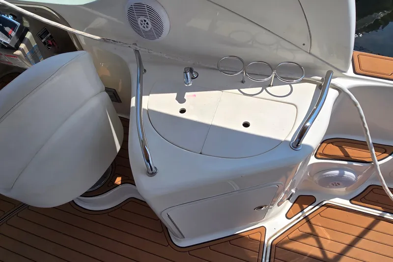 Slide: The Image of 2003 Sea Ray 280 Sundancer cockpit with seating, sink, and cup holders. - 17