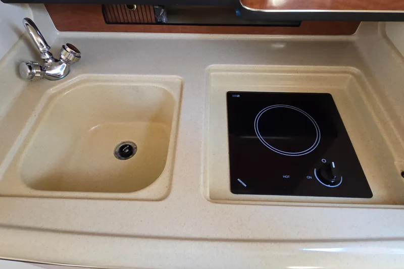 Slide: The Image of 2003 Sea Ray 280 Sundancer kitchen with sink and electric stove. - 23