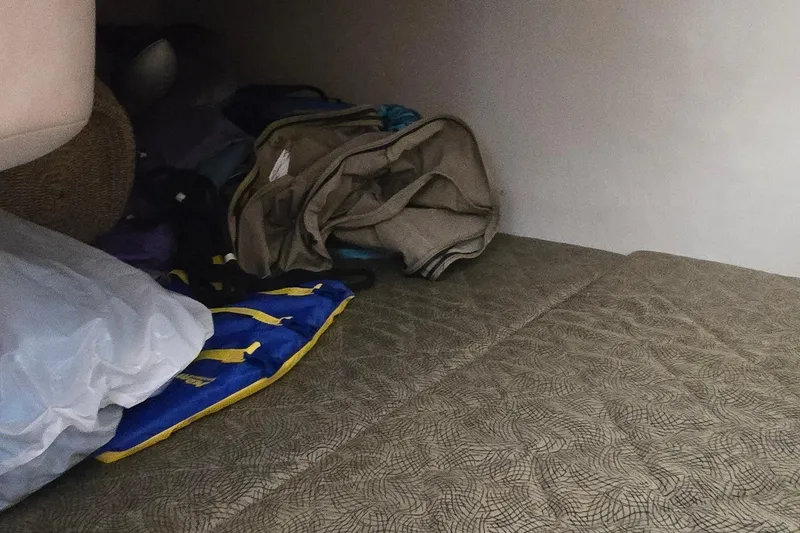 Slide: The Image of Interior cabin storage of 2003 Sea Ray 280 Sundancer with bags and life jacket. - 29