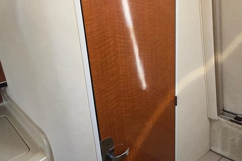 Slide: The Image of Interior cabin door of 2003 Sea Ray 280 Sundancer boat, featuring wood finish. - 30