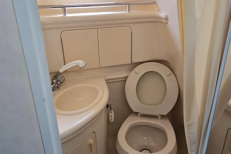 Slide: The Image of Compact bathroom in 2003 Sea Ray 280 Sundancer boat, featuring sink and toilet. - 32