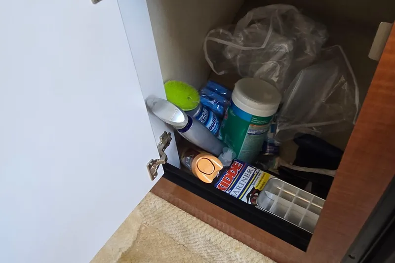 Slide: The Image of Open cabinet on 2003 Sea Ray 280 Sundancer with cleaning supplies and miscellaneous items. - 33