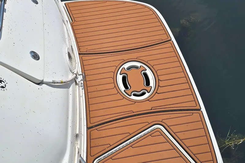 Slide: The Image of 2003 Sea Ray 280 Sundancer swim platform with teak-style decking, docked on calm water. - 5