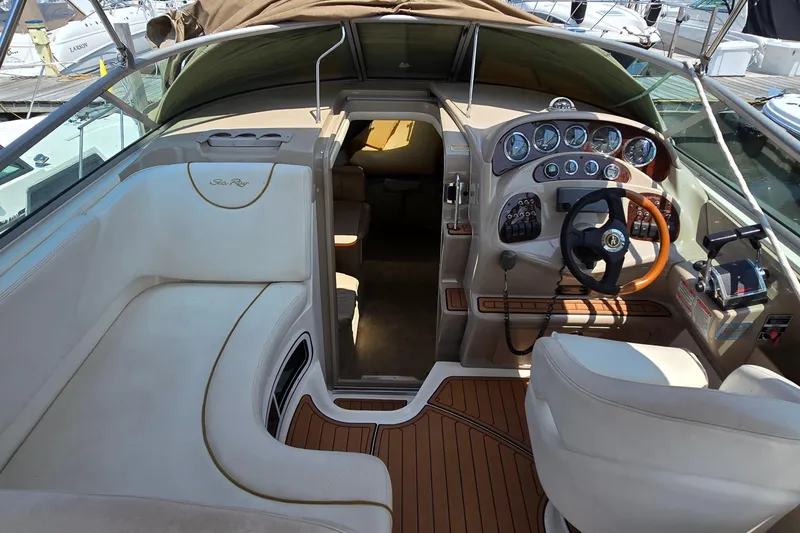 Slide: The Image of 2003 Sea Ray 280 Sundancer cockpit with luxurious seating and modern dashboard controls. - 6