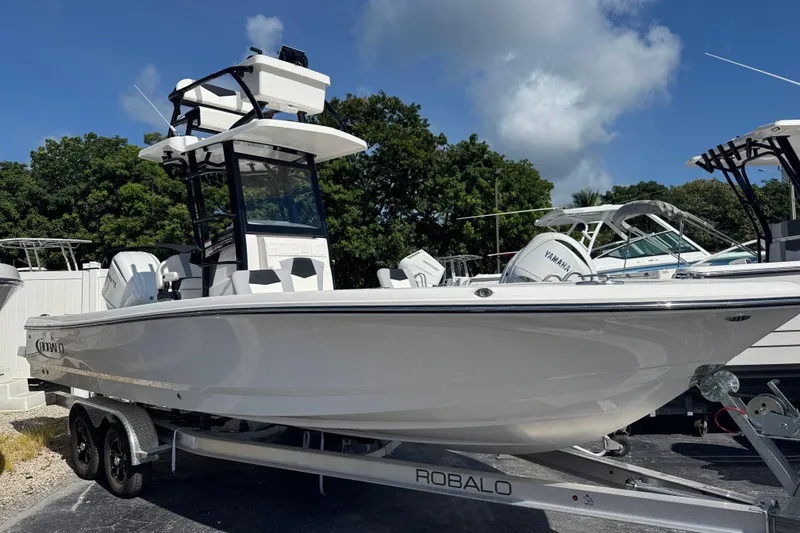 The Image of 2025 Robalo 246 Cayman SD boat on trailer, side view, clear sky background. - 0