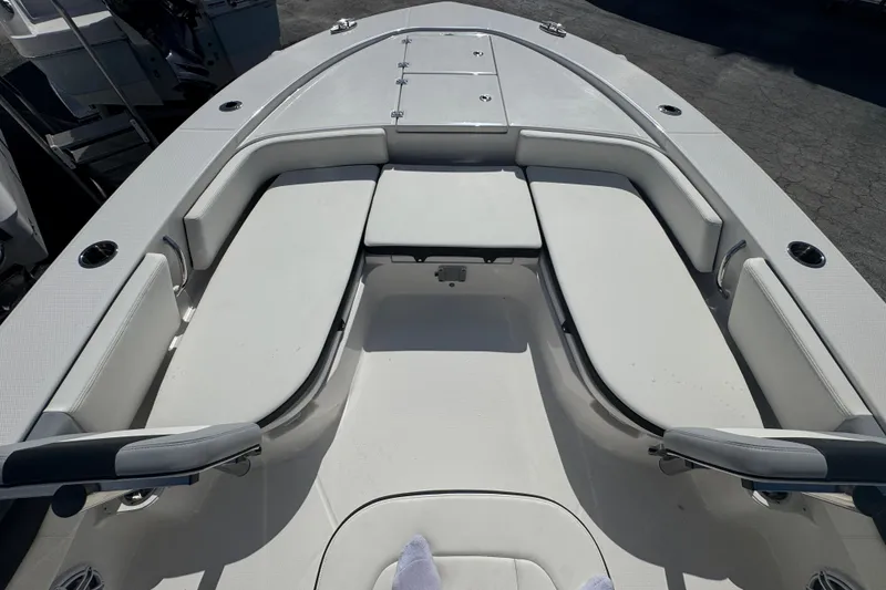 Slide: The Image of 2025 Robalo 246 Cayman SD boat interior with cushioned seating and cup holders. - 10