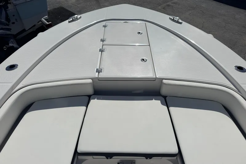 Slide: The Image of 2025 Robalo 246 Cayman SD boat deck with cushioned seating and storage compartments. - 11