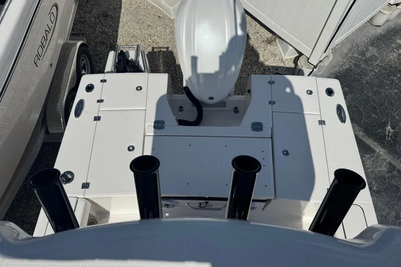 Slide: The Image of 2025 Robalo 246 Cayman SD boat deck with rod holders and storage compartments. - 24
