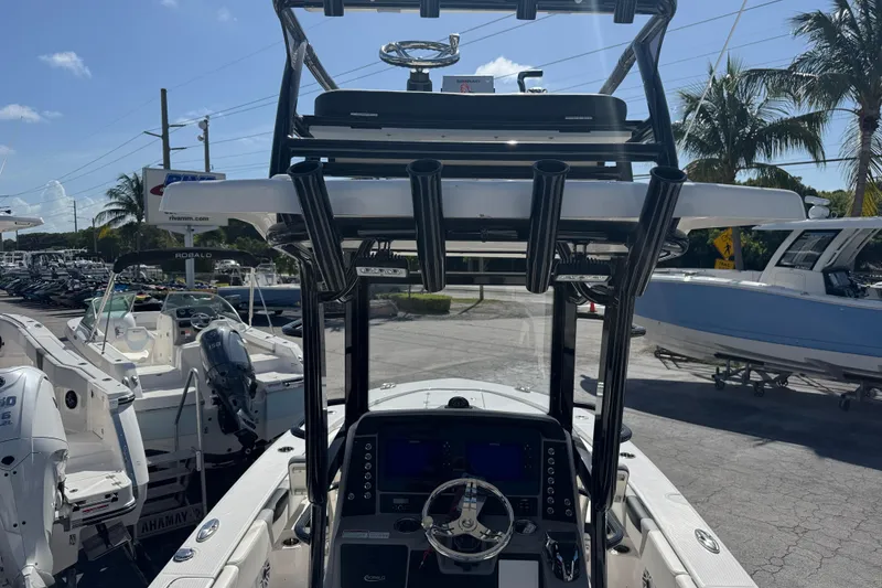 Slide: The Image of 2025 Robalo 246 Cayman SD boat with advanced dashboard and rod holders, displayed outdoors. - 5