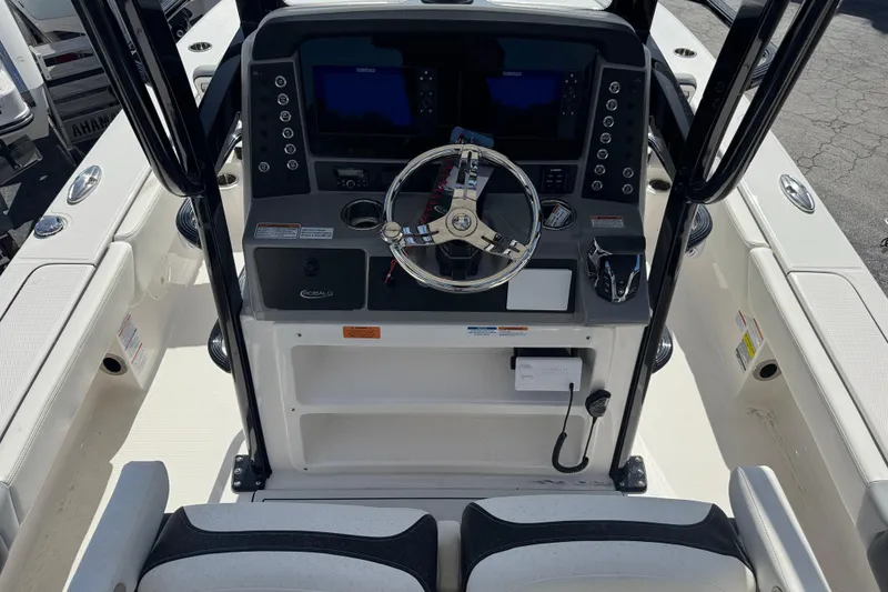 Slide: The Image of 2025 Robalo 246 Cayman SD boat console with steering wheel and navigation controls. - 6