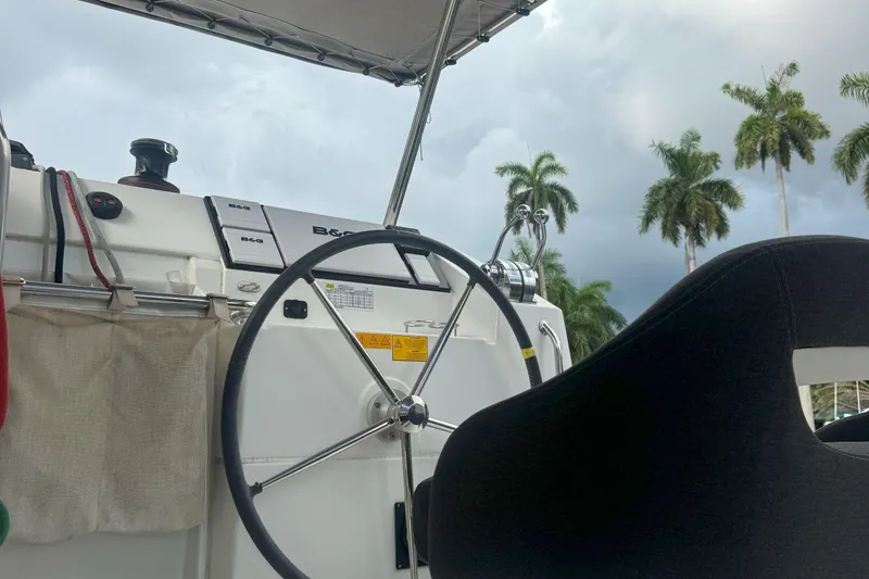 Slide: The Image of Steering wheel of 2022 Lagoon 40 catamaran with palm trees in background. - 14