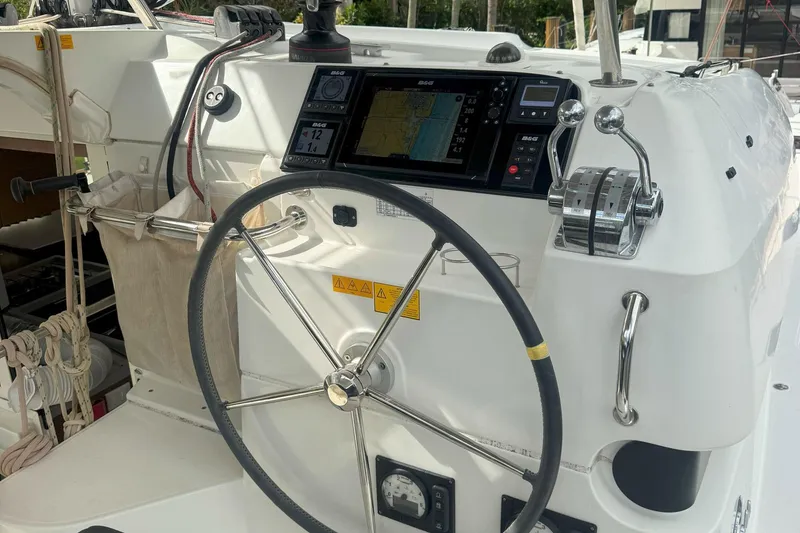 Slide: The Image of Helm of 2022 Lagoon 40 catamaran with navigation equipment and steering wheel. - 15