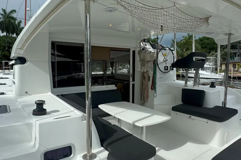 Slide: The Image of 2022 Lagoon 40 catamaran cockpit with seating, table, and helm station. - 19