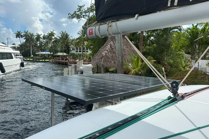 Slide: The Image of 2022 Lagoon 40 catamaran with solar panels docked by tropical waterfront. - 20
