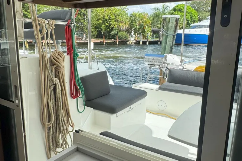 Slide: The Image of 2022 Lagoon 40 catamaran interior view with ropes and seating, docked by water. - 21