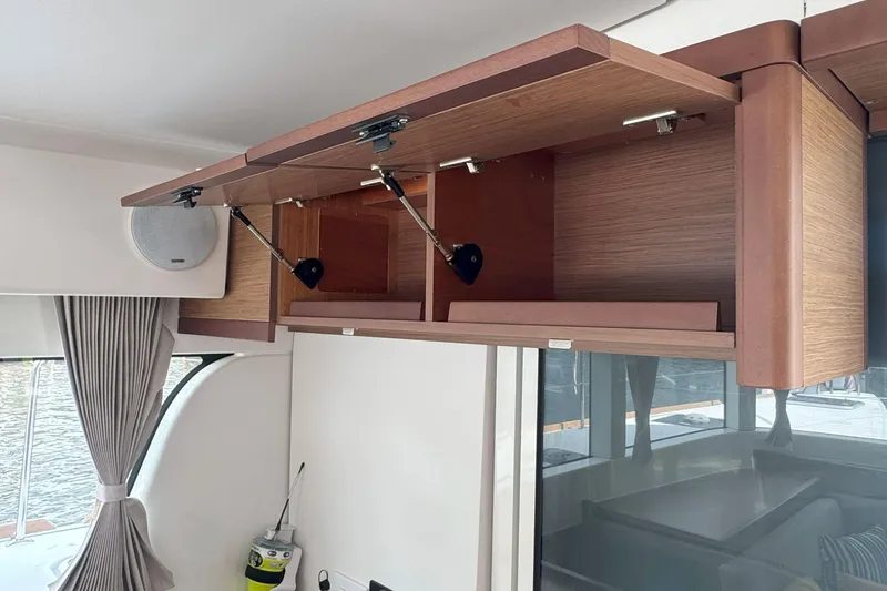 Slide: The Image of Open wooden cabinets in a 2022 Lagoon 40 yacht interior, showcasing modern design. - 34