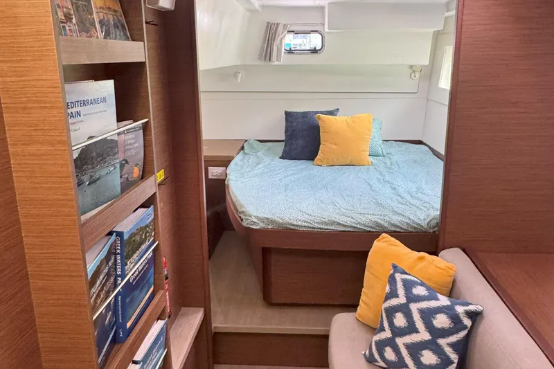 Slide: The Image of Cozy cabin interior of 2022 Lagoon 40 catamaran with bed, cushions, and bookshelf. - 37