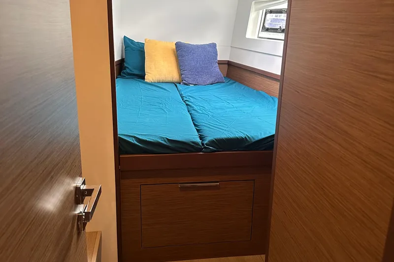 Slide: The Image of Cozy cabin interior of 2022 Lagoon 40 catamaran with teal bedding and pillows. - 44