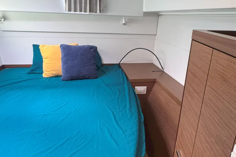 Slide: The Image of Cozy cabin interior of 2022 Lagoon 40 catamaran with colorful pillows and wooden cabinetry. - 51