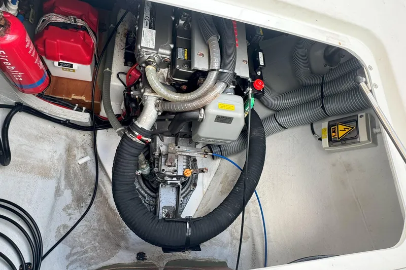 Slide: The Image of Engine compartment of a 2022 Lagoon 40 catamaran with visible components and fire extinguisher. - 56